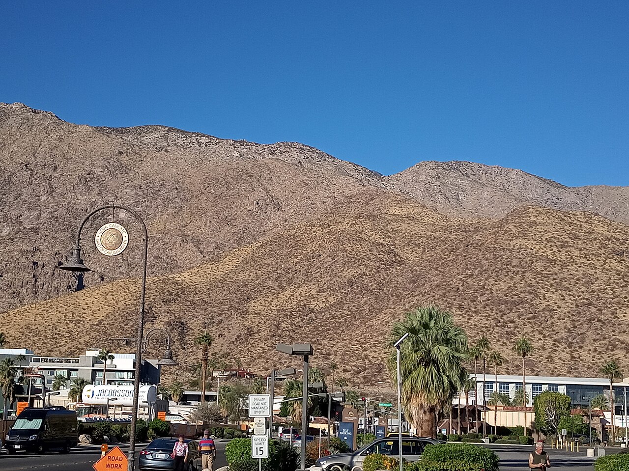 A round sign with the insignia of the Agua Caliente Band of Cahuilla Indians, suspended from a streetlamp post in downtown Palm Springs, California.