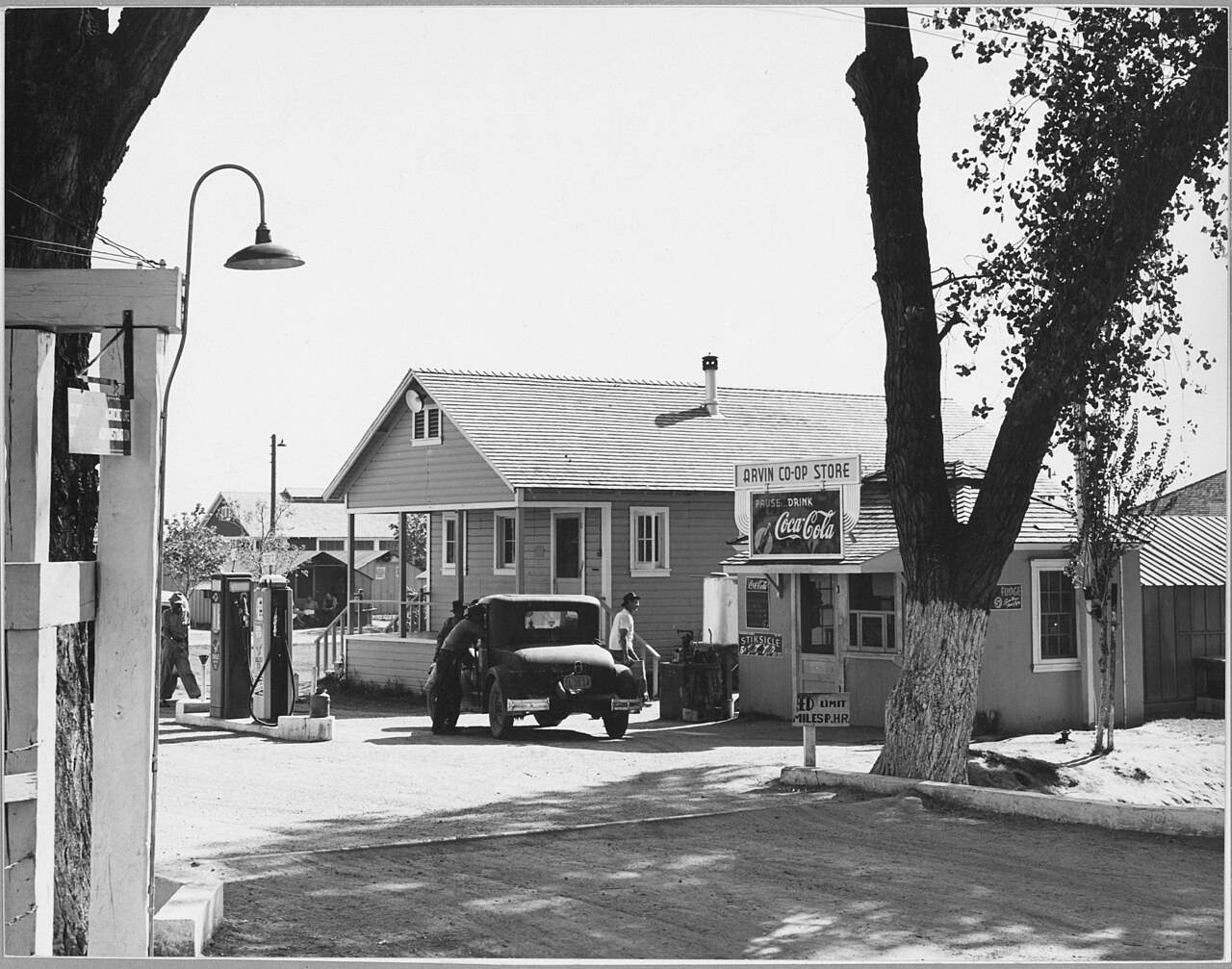 Scope and content:  Full caption reads as follows: Arvin Kern County, California. Photograph made from the entrance of the Arvin Farm Labor Camp (F.S.A.). Shows the Arvin co-op store and gas station, this co-operative established December 15, 1939, by 60 camp members each of whom contributed $1 to start the enterprise. The gas pumps are now one third paid for and the store paid a 14 percent dividend in March 1940. Two other camps (F.S.A.) have started similar co-operative endeavors.