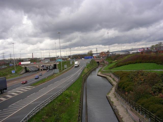 Canal and Motorway, Chadderton, Oldham. For a few hundred metres the M60 Motorway and the Rochdale Canal run side by side. Although separated by only a few metres in space they are separated by about 200 years in time, as this section of the canal (part of Britain's first trans-Pennine canal route) opened in 1799.
