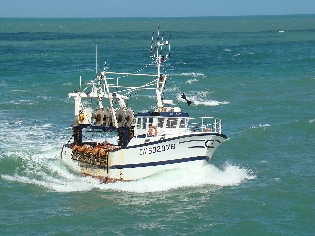 A fishing boat returns to port in w:Fécamp, w:Normandy