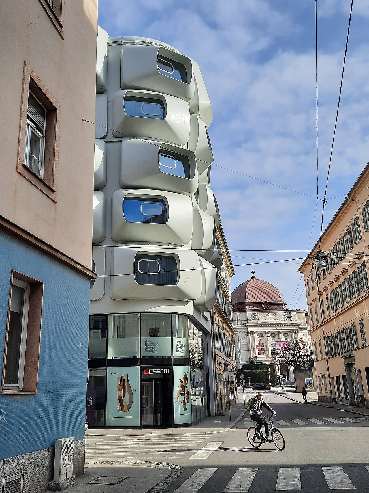 Das Apartmenthaus in der Burggasse 15 in Graz ist ein Entwurf der Pritzker-Preisträgerin Zaha Hadid, die, wenige Wochen nach dem Spatenstich, in Miami verstarb. Fertiggestellt wurde der Komplex im Jahr 2020 nach einer 17- jährigen Planungs- und Bauzeit.