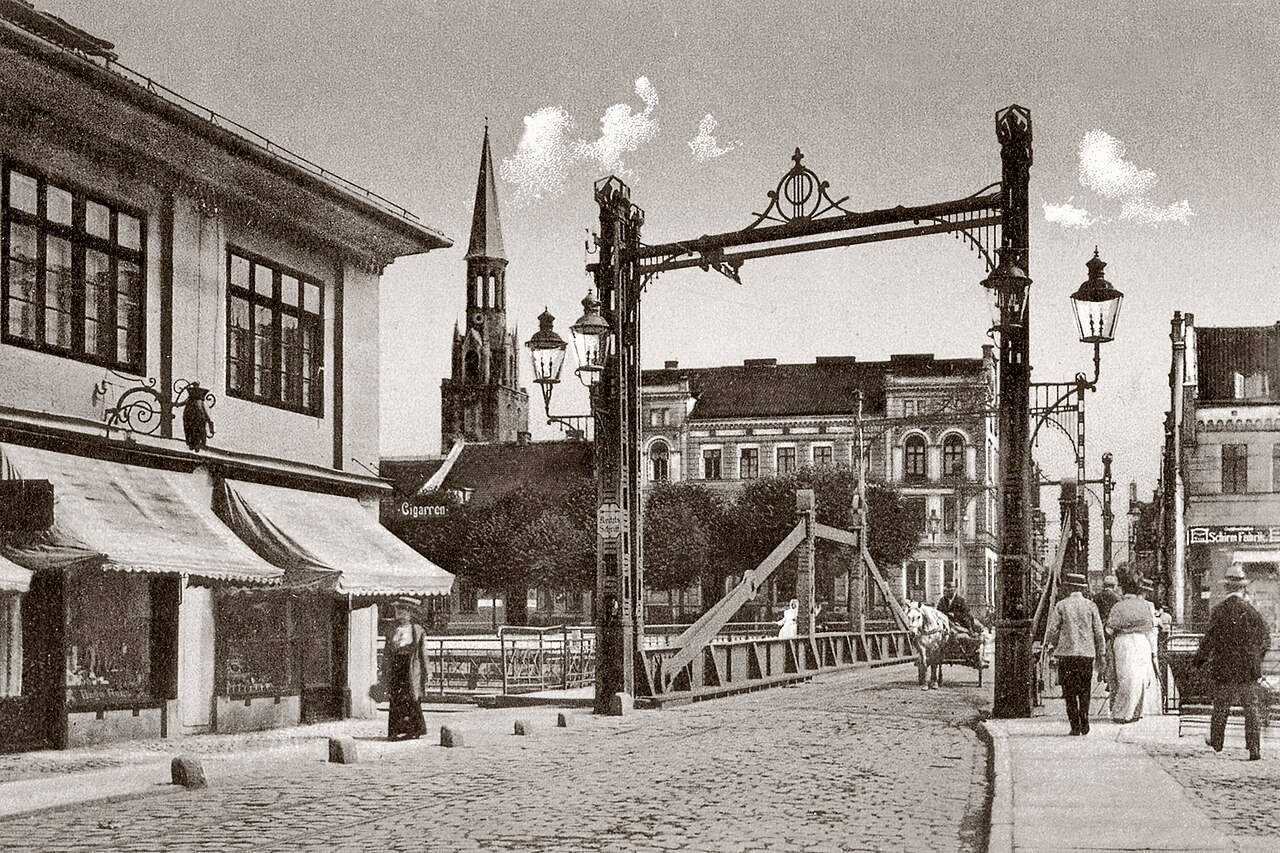 Biržos tiltas (Burzovní most) před r. 1930. Pohled od severu. V pozadí věž kostela Sv. Jana (dnes je na jeho místě volné prostranství na jižní straně východní části ulice Turgaus gatvė)