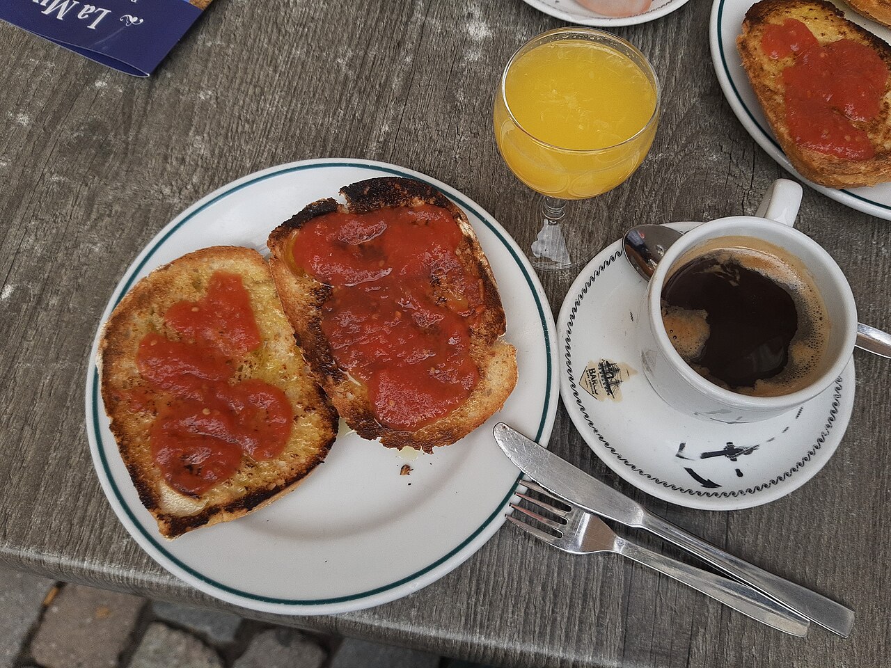 Spanish breakfast of orange juice, coffee and tostada con tomate, served outside at restaurant La muralla, in Latina, Madrid