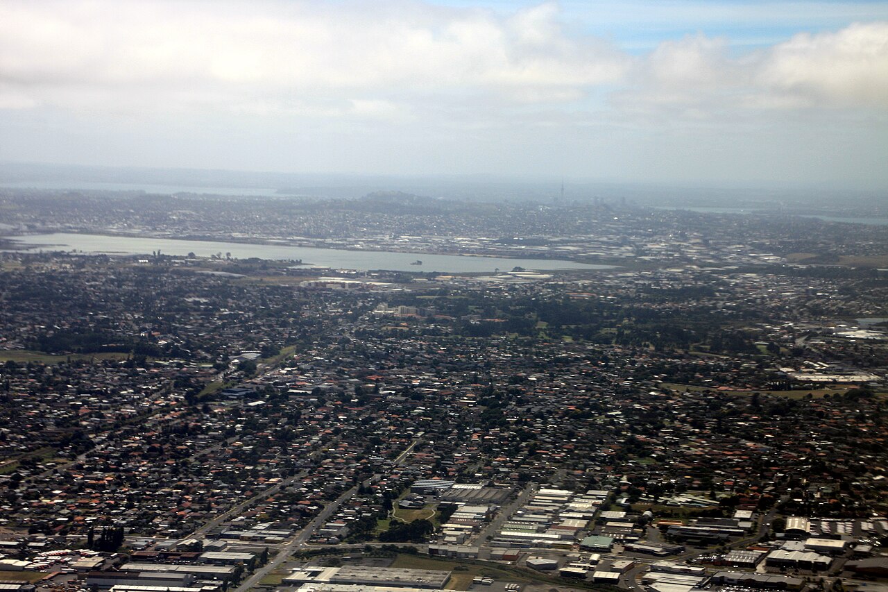 2009 aerial view of South Auckland (Mangere East and Otahuhu), looking north towards the Mangere Inlet. The Auckland CBD is in the background.