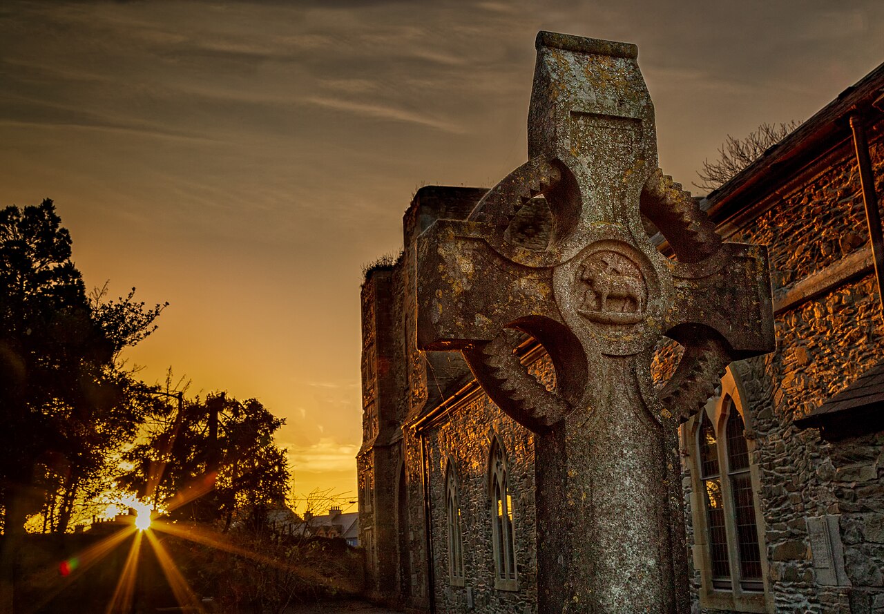 Hand cut Celtic Cross at St. David's church Naas.  Captured at sunset on Remembrance Sunday.  The carving of the stone is replicated in the window carvings and communion table in the church.