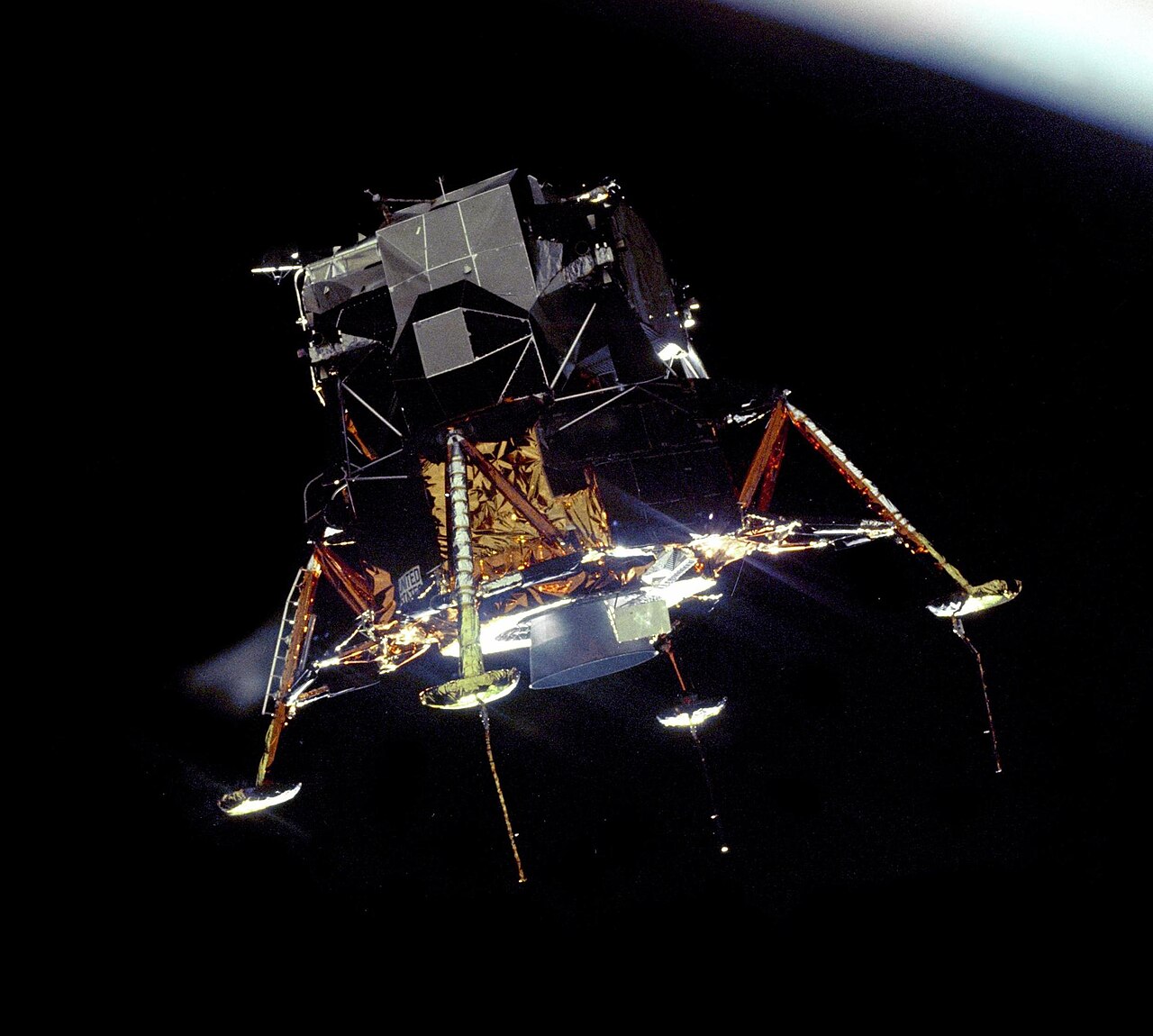 The Apollo 11 Lunar Module Eagle, in a landing configuration was photographed in lunar orbit from the Command and Service Module Columbia. Inside the module were Commander Neil A. Armstrong and Lunar Module Pilot Buzz Aldrin. The long rod-like protrusions under the landing pods are lunar surface sensing probes. Upon contact with the lunar surface, the probes sent a signal to the crew to shut down the descent engine.