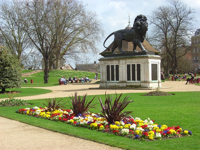 The Forbury Gardens in the English town of Reading. A lot of effort goes into the creation of colourful floral displays in the gardens. Here polyanthuses provide a garish splash of colour in front of the Maiwand Lion, a memorial to lives lost during the Afghan Wars. The Forbury Hill, an artificial mound of unknown origin, can be seen to the left of the lion.