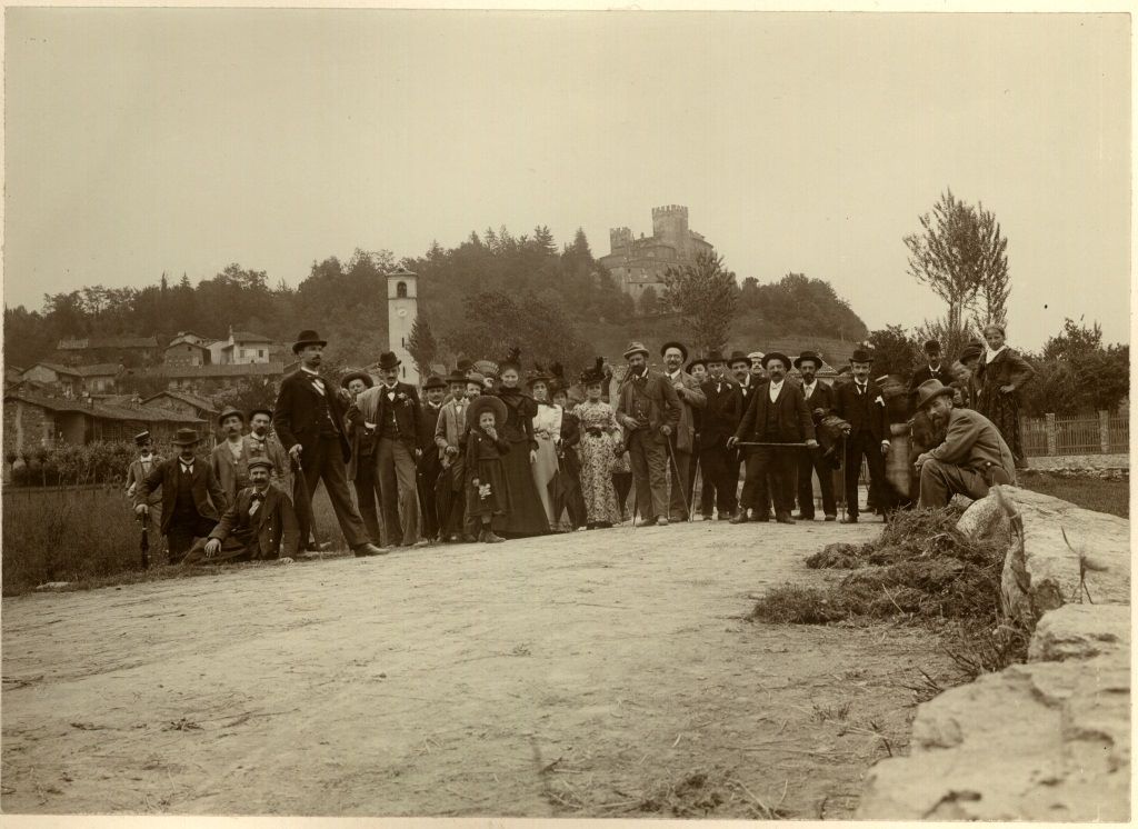 A Reano. Valle Del Sangone- Reano, Grande Gruppo Di Escursionisti In Posa Col Paese Sullo Sfondo; 1900 ca.; stampa al citrato; 117X165