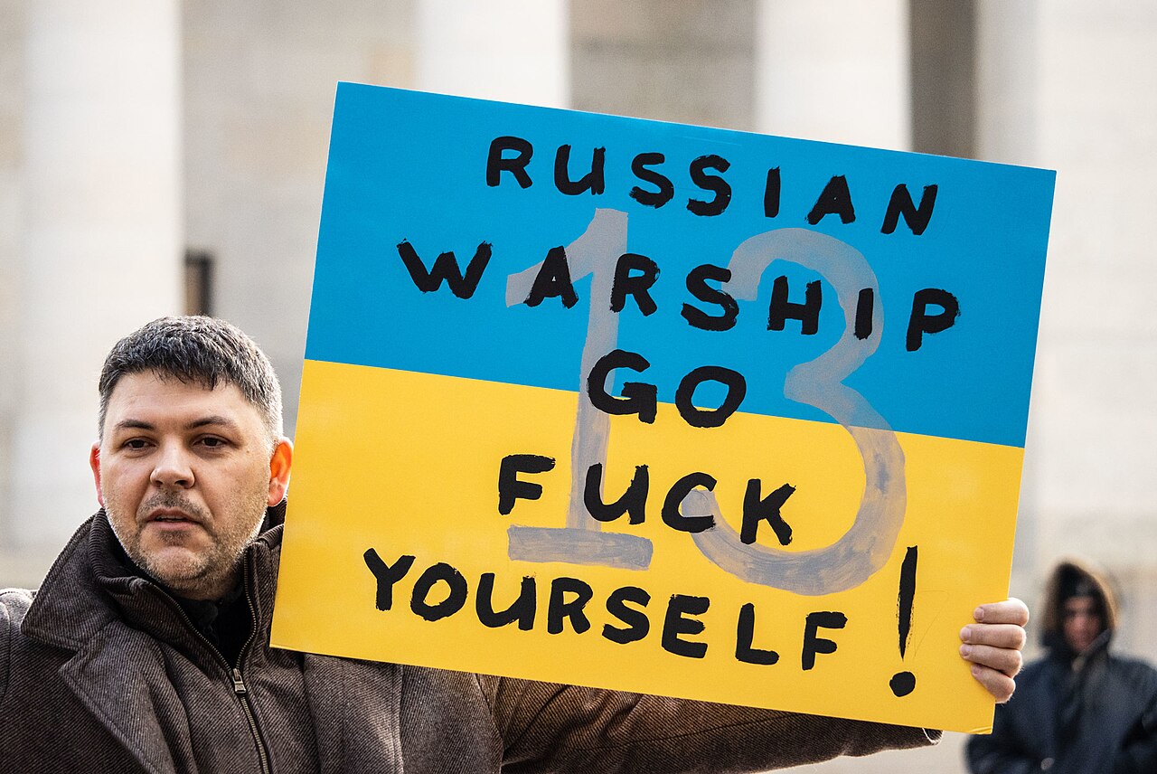 Protester carrying a sign with a slogan at rally in support of Ukraine, outside Ohio Statehouse,[1] in Columbus, Ohio, United States, 26 February 2022 - bIMG_0195.The slogan refers to the famous statement “Russian warship, go fuck yourself” made by a Ukrainian soldier during the Battle of Snake Island on 24 February 2022.