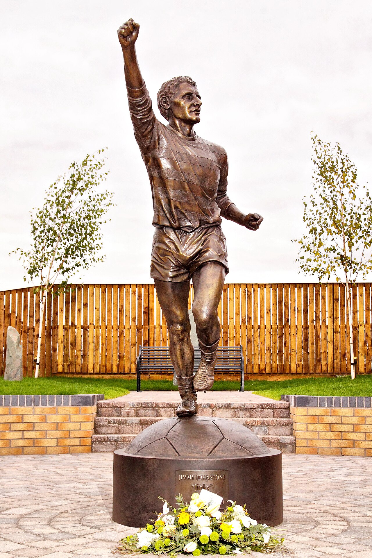 The legendary Celtic football player Jimmy 'Jinky' Johnstone bronze statue by John McKenna sculptor. Created by McKenna in his Ayrshire studio bronze foundry for the memorial garden of Jimmy Johnstone in Viewpark, Glasgow. Life-size bronze.