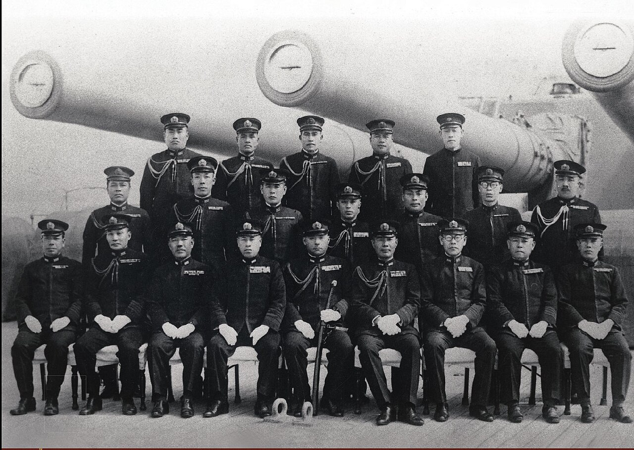 Admiral Yamamoto and his staff posing with the battleship Yamato's 18.1-inch (46 cm) gun turret 3 shortly after commisioning