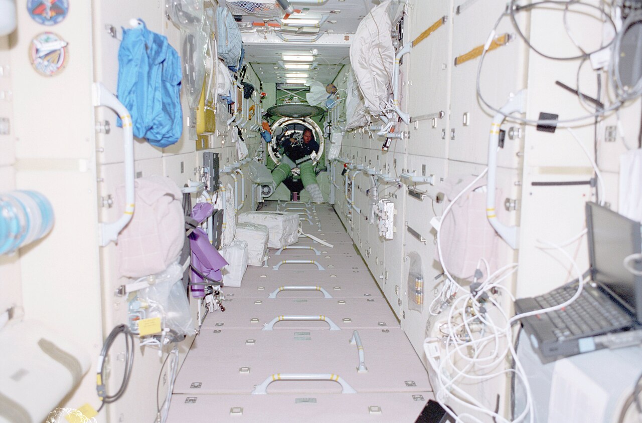 Mission Specialist Thomas Jones floats through the Zarya Functional Cargo Block (FGB) carrying hardware for the IMAX Camera. Photos were taken during Mission STS-98, International Space Station (ISS) Flight 5A. Image ID: sts098-338-023