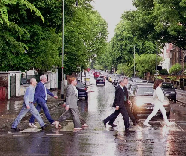Cassini imaging team with Carolyn Porco in front, all dressed in costume, re-staging the famous Abbey Road photograph.  June 2001.  The Pauls are even barefoot and carrying cigarettes.