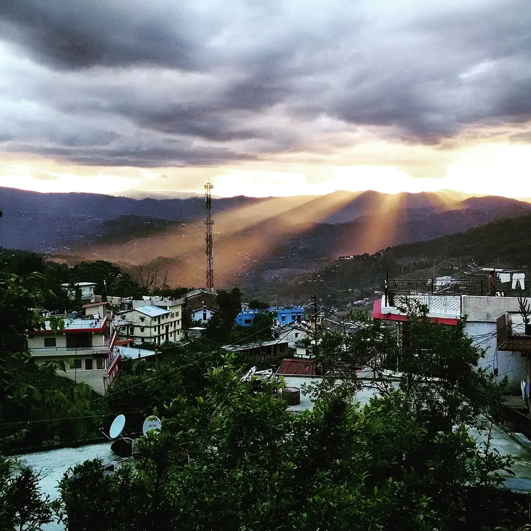 View of almora city after rainfall. The sunlight is penetrating the black clouds