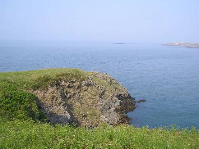 East Mouse/Ynys Amlwch East Mouse Island is visible in the distance beyond the cliff in the foreground.
The rocks in Bull Bay date back about 570 million years, making them among the oldest in Wales.