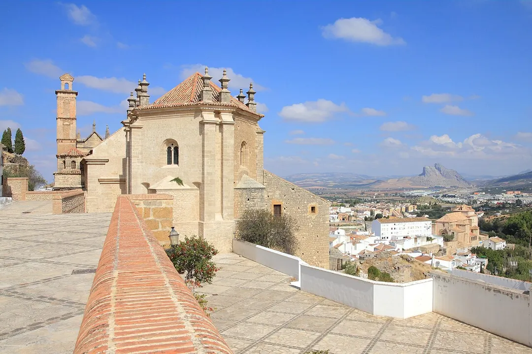 Royal Collegiate Church of Santa María la Mayor in Antequera, Andalusia, Spain. View of Antequera town on the right. Peña de los Enamorados ("The Lovers' Rock") mountain in the background on the right.