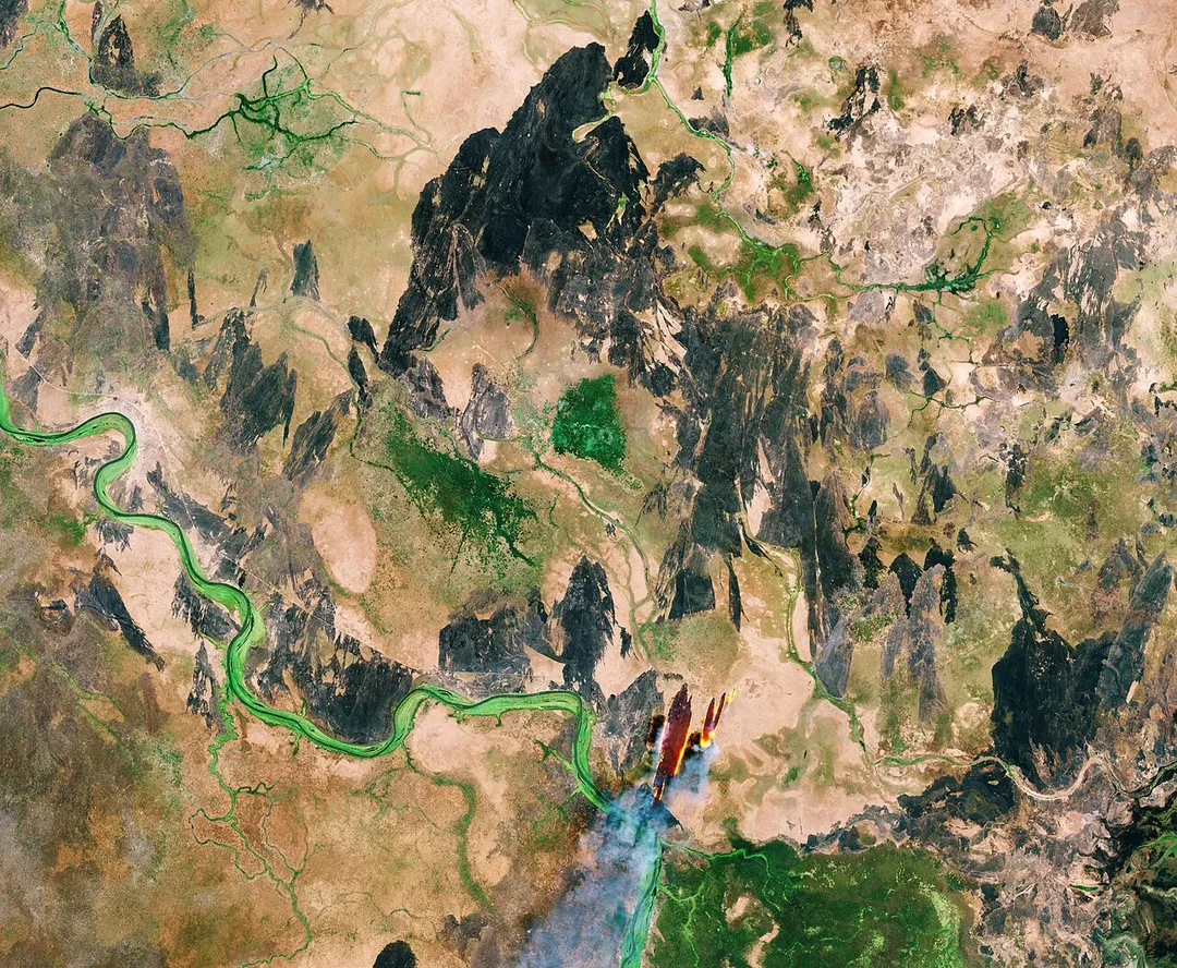 The Copernicus Sentinel-2B satellite takes us over South Sudan. Having gained independence from Sudan in July 2011, South Sudan is the youngest country in the world. It has an estimated population of 13 million people, more than 80% of whom live in rural areas. Most of the population relies on farming, fishing or herding to meet their food and income needs.
The Sobat river is traced in a vibrant green colour along the left part of the image. This is the most southerly of the great eastern tributaries of the White Nile, the section of the Nile between Malakal, South Sudan and Khartoum, Sudan.
Tropical forests, swamps and grassland make up the majority of South Sudan’s terrain. A large, swampy area called the Sudd, which is about 320 km wide and 400 km long, can be found in the centre of the country. This is thought to be one of the largest freshwater ecosystems in the world and is fed by the White Nile and rainfall runoff from surrounding areas. It is home to large fish populations, millions of migratory birds, and various endangered species.
The area has also provided shelter for refugees fleeing the ongoing Sudanese civil war, which broke out in South Sudan in December 2013.
The red and gold in the lower-central part of the image shows smoke from a fire. The smoke is being driven by a northerly wind. The black parts of the image, similarly, show burnt areas of land – possibly the result of slash and burn agriculture. By burning dry grass, herders are able to fertilise the soil with ash, promoting new growth that can be used to feed livestock. Subsistence farmers also tend to use this method to manage land, returning nutrients to the soil and clearing the ground of unwanted plants in the process. Some of the negative longer-term impacts of this practice include air pollution, deforestation and erosion.
Sentinel-2 carries an innovative wide swath high-resolution multispectral imager for observing our land and vegetation. The mission mainly provides information for agricultural and forestry practices and for helping manage food security.

This image, which was captured on 18 January 2018, is also featured on the Earth from Space video programme.