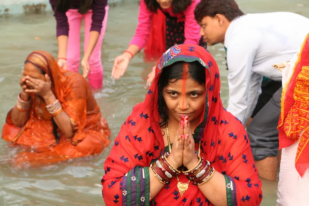 Sandhya Arghya (evening offerings)
This day is spent preparing the prasad (offerings)at home. On the eve of this day, the entire household accompanies the Vratins to a riverbank, pond or a common large water body to make the offerings (Arghya) to the setting sun. It is during this phase of Chhath Puja that the devotees offer prayers to the just setting sun. The occasion is almost a carnival. Besides the Vratins, there are friends and family, and numerous participants and onlookers, all willing to help and receive the blessings of the worshipper. The folk songs sung on the evening of Chhath.