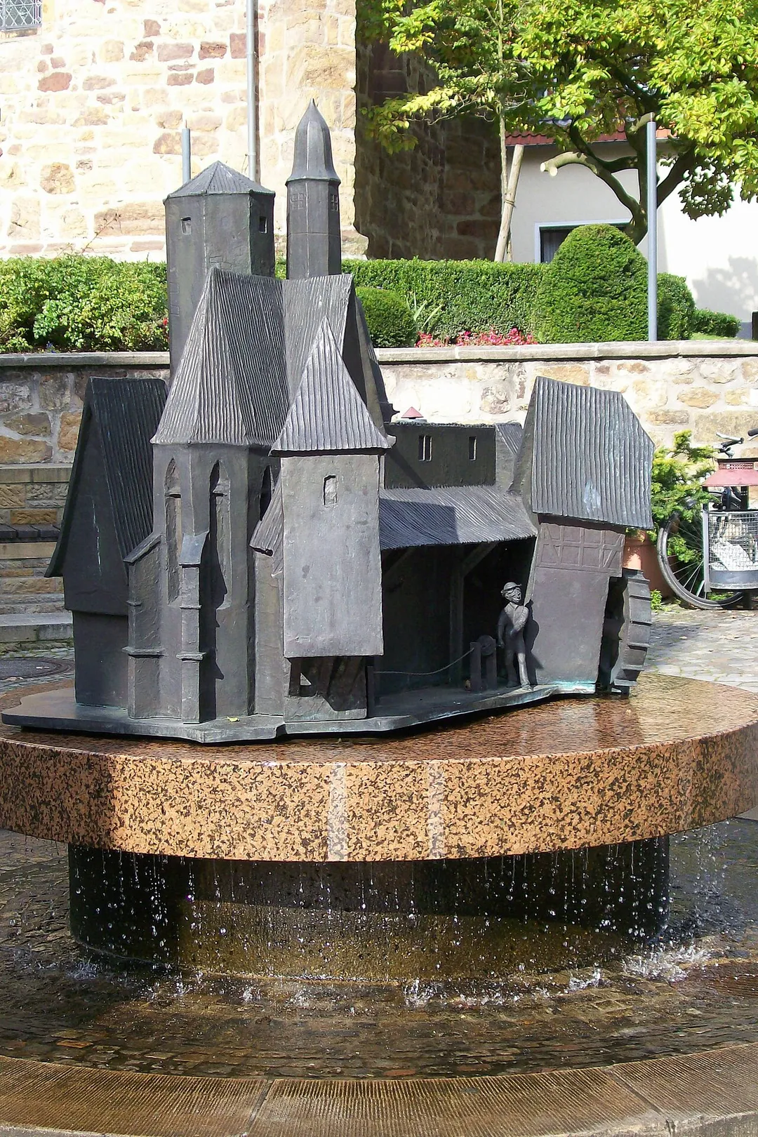 Handwerkerbrunnen in Bad Iburg, Niedersachsen, von dem Osnabrücker Künstler Hans Gerd, in der Großen Straße unterhalb der de:Fleckenskirche St. Nikolaus, am 4. April 1992 der Öffentlichkeit übergeben.
