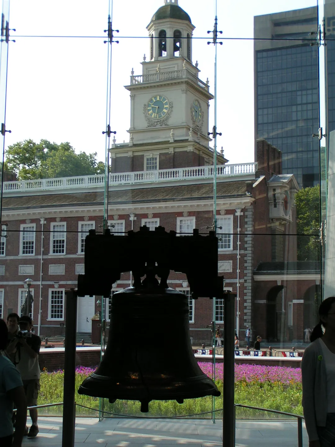 The Liberty Bell hangs in the Liberty Bell Center, with Independence Hall visible through the glass.Liberty Bell, Independence Hall