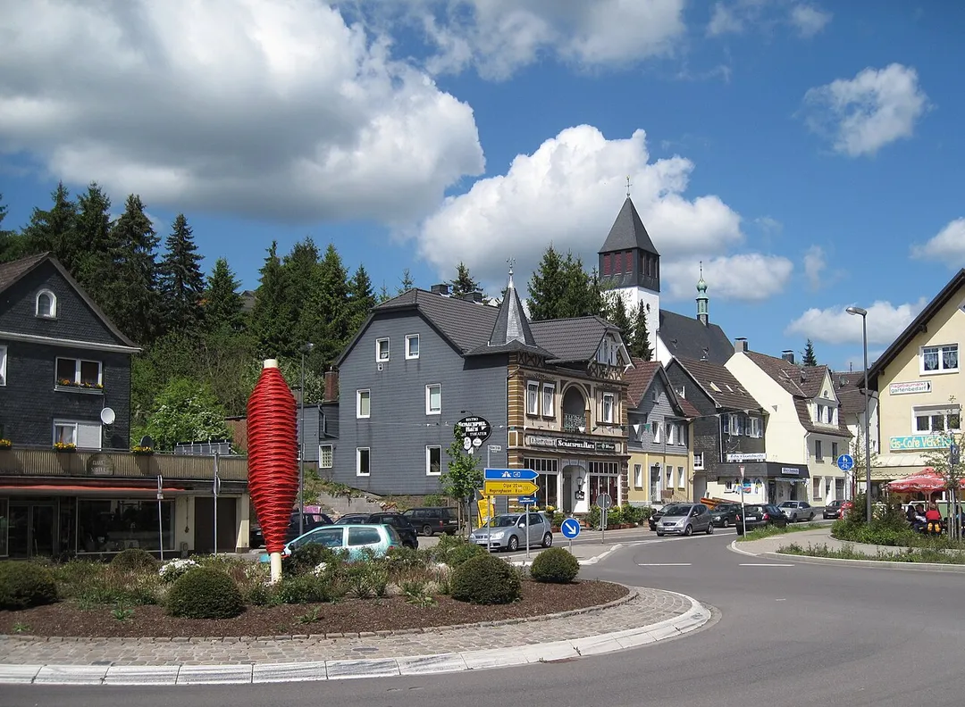 Kunst am Kreisverkehr (Südkreisel) an der B 55 / Südring / Kölner Straße in Bergneustadt. Verzinkte Garnspindel. Die rot lackierte Spindel ist etwa vier Meter hoch und wiegt 1,5 Tonnen. Sie wurde Bergneustadt vom Textilunternehmer Karl Adolf Krahwinkel zur Erinnerung an die textile Vergangenheit des Ortes geschenkt.