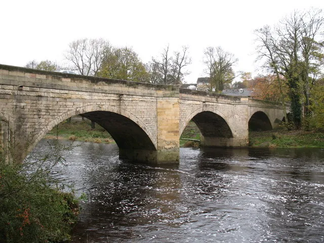 Boston Spa
Original description:
Boston Spa Bridge

A fine stone bridge spanning the Wharfe at Boston Spa. The bridge dates from 1772, replacing a ford.  It is said that the bridge was constructed so that the local hunt could cross the river without fear of a wetting.