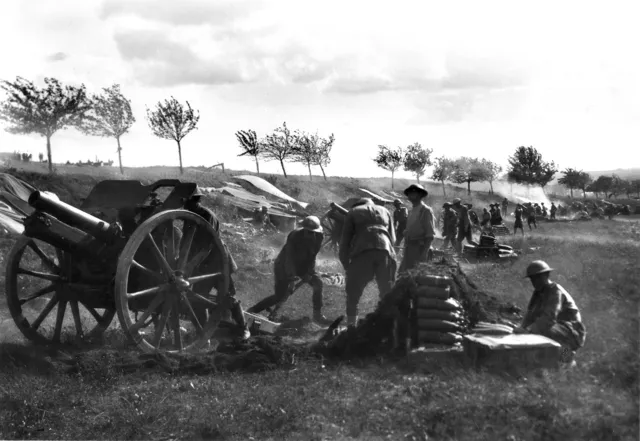 The 108th Howitzer Battery in action at Bray using 4.5 inch Mk I Howitzers. The troops of the 3rd Australian Division whom the Battery was supporting were then engaged beyond Suzanne (France, Somme).

Identified, left to right 
21492 Corporal J. F. Yates MM (partially obscured by the gun)
21437 Bombardier J. W. Larton (sic.. probably J T  Wharton) (shovelling)
37417 Gunner (Gnr) H. Harnett (back to camera)
24557 Gnr C. F. H. Ipsen (looking up)
23094 Gnr F. (sic... John ?) Southwell (extreme right foreground)
32887 Gnr C. Dun (in the background between Harnett and Ipsen)
23073 Gnr A. McDonald (directly behind Ipsen)
32962 Gnr Stockley (behind McDonald)
Location : Belgium: Wallonie, Bray.
NOTE : This version of the photograph has brightness and contrast artificially increased to highlight details.