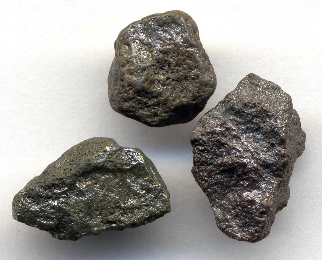 Carbonado diamondites (small specimen at top: 4.05 carats and 9x9x6 mm in size; medium-sized specimen at left: 4.07 carats and 10x13x7 mm in size; large specimen at right: 5.09 carats and 12x6x6 mm in size).
Diamondites are rare, polycrystalline, nearly monomineralic diamond rocks. The term “diamond” refers to a mineral, while the term “diamondite” refers to a diamond rock. The three diamondites depicted here are a variety referred to as “carbonados” in the diamond trade. Carbonados are typically a dark brown to blackish color. The shiny luster seen in the specimens below is typical for carbonados (adamantine luster). Individual diamond crystals in carbonado diamondites are exceedingly small, typically <20 m. Carbonados are also characterized by having obvious porosity in all portions of the rock (see pits in specimens shown here).
Despite a relative abundance of published research, the origin of carbonado diamondites is still unresolved. Some workers interpret them as being crustal in origin. Some consider them to have a mantle origin. Some suggest that they are impact-generated. Recent research has indicated that carbonado diamondites are extraterrestrial - extrasolar, in fact (apparently supernova-generated).
True carbonado diamondites have only been recorded from Brazil and the Central African Republic (CAR). Considering South America & Africa were physically connected for a long time while a part of the ancient Gondwana continent, these two carbonado occurrences may ultimately represent one deposit.
The specimens shown here are from the CAR. In the CAR, carbonado diamondites are recovered from modern to subrecent alluvial gravels (placer deposits) below the topsoil. They are only found in & immediately adjacent to the outcrop belt of the Carnot Formation (Cretaceous). The Carnot Formation is an ancient fluvial & lacustrine siliciclastic unit that hosts scattered diamonds & carbonados. Upon weathering & erosion, any included diamonds in the Carnot Formation enter modern river systems’ sediment loads.
Age: carbonado diamondites are exceedingly old. Published research indicates they are 3.2 billion years old (mid-Mesoarchean).
Locality: unrecorded locality in the “Bangui region” (area between the cities of Bangui and Berberati), southwestern Central African Republic, central Africa.