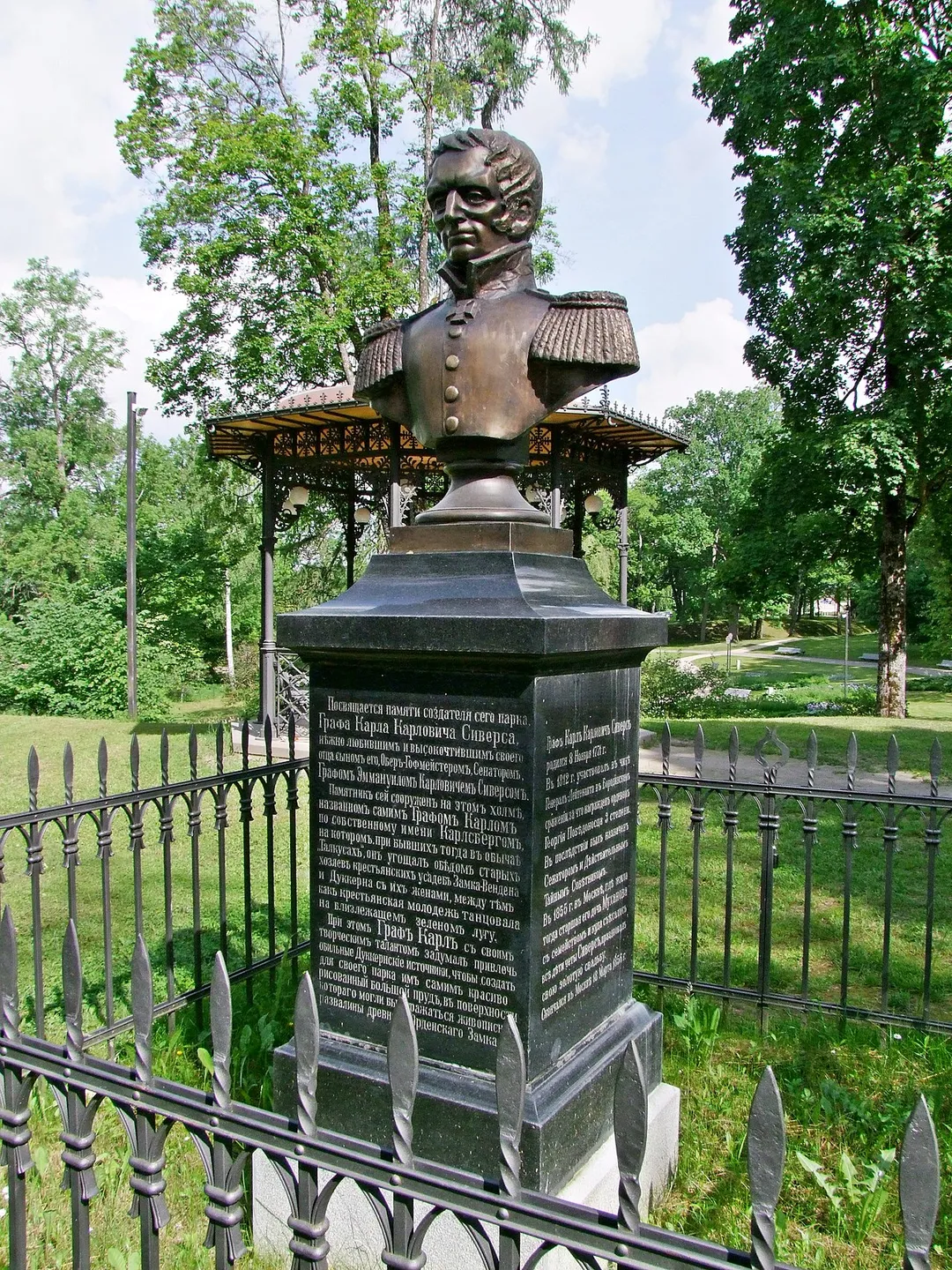 Karl Karlovich Sievers (Graf Carl Gustav Sievers, 08.11.1771 - 18.03.1856) took part to the Battle of Borodino (7 September 1812) as General-Lieutenant, for which he was decorated.  
He is also remembered for having, as owner of Cesis Castle manor estate, created the Maija parks as a public space in the early 1830's.
In 1908, his son Emanuel had the bust of his father erected on the hilltop of the Maija park, Cēsis, Latvia. 

On the socle, epithaphs in Russian and German.