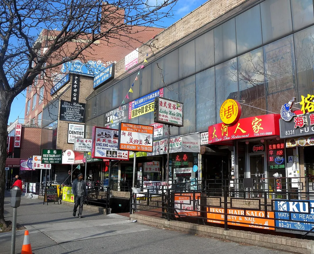 Looking north at shops on Broadway south of the former rail line on a sunny early afternoon. ZIP 11373.
