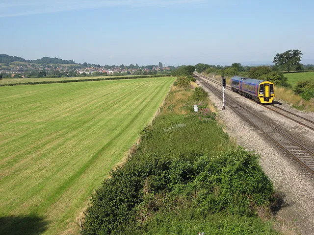 Travelling from Gloucester to Cheltenham The train is about to pass under the bridge north of Reddings Farm. Lower slopes of Tinker's Hill can just be seen on the left behind the houses in Churchdown.