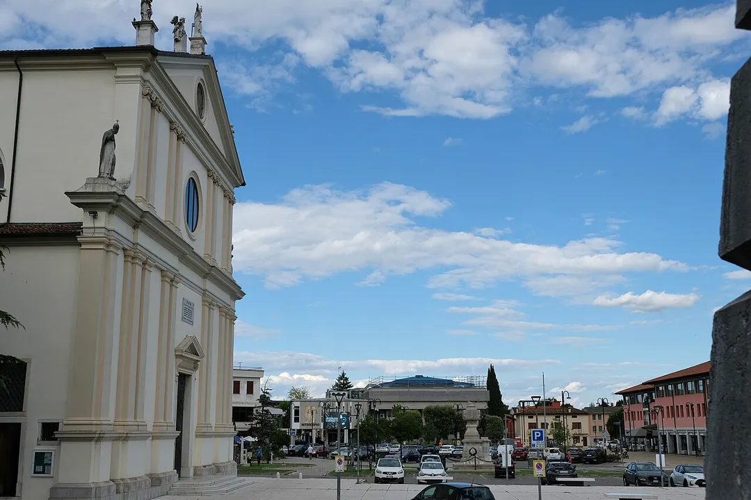 View on piazza della Vittoria (Victory square) in Cordenons. On the left the facade of the Duomo di Santa Maria Maggiore, in the middle the town hall of Cordenons, on the right a glimpse of the stones at the base of the duomo's bell tower.