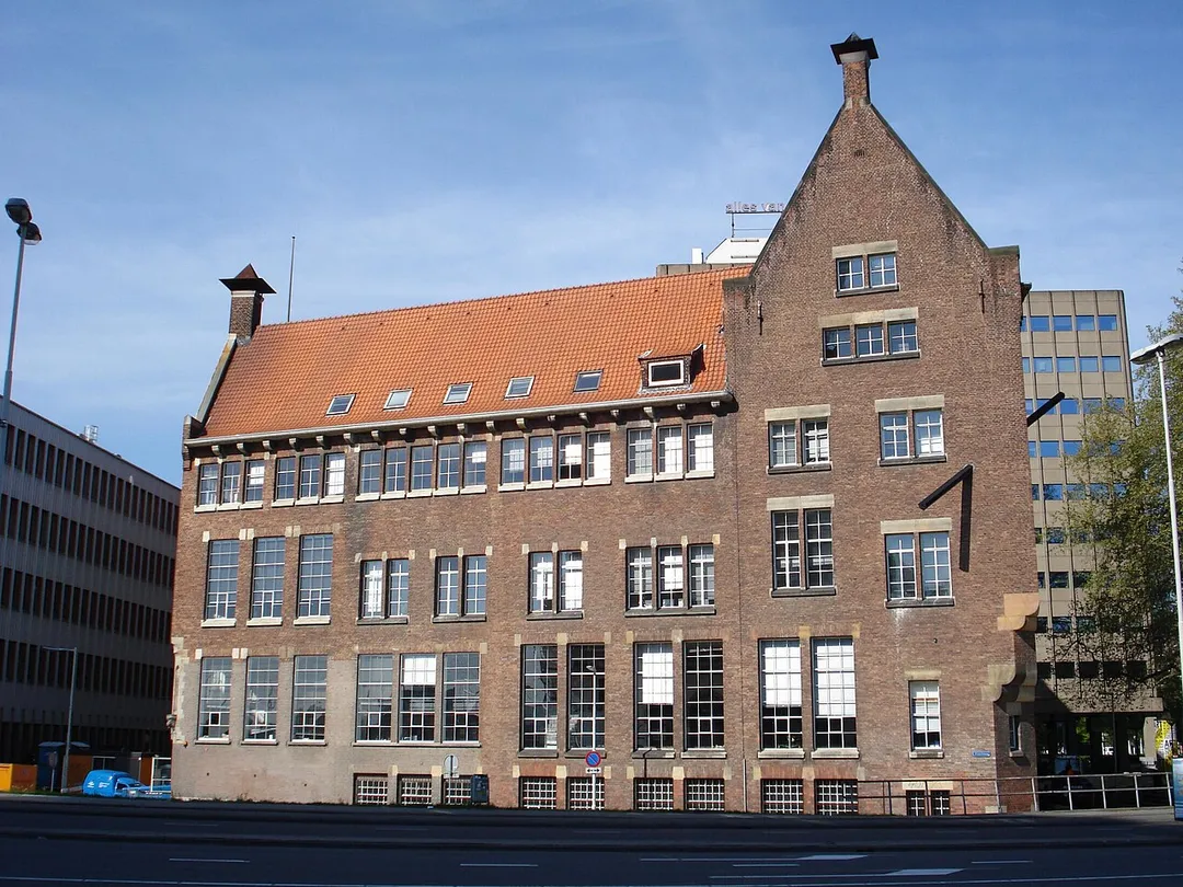 Rotterdam, Blaak 10. Rijksmonument. Hier afgebeeld is de zijkant van het gebouw aan de Vissteeg gezien vanaf de overzijde van de langslopende Andre Van der Louwbrug in 2007. Aan de achterzijde van het gebouw (links) loopt de Wijnstraat. Op de andere hoek (rechts) aan de Blaak hoog in de gevel bevind zich het kunstwerk Zonder titel (1985) van Jan van Munster. [1] Dit aanzicht is een historische opname, die niet meer zo is waar te nemen. Met de bouw van het hooggebouw OurDomain is een deel van deze gevel (hier het linkerdeel) aan het zicht onttrokken. (bron [1])