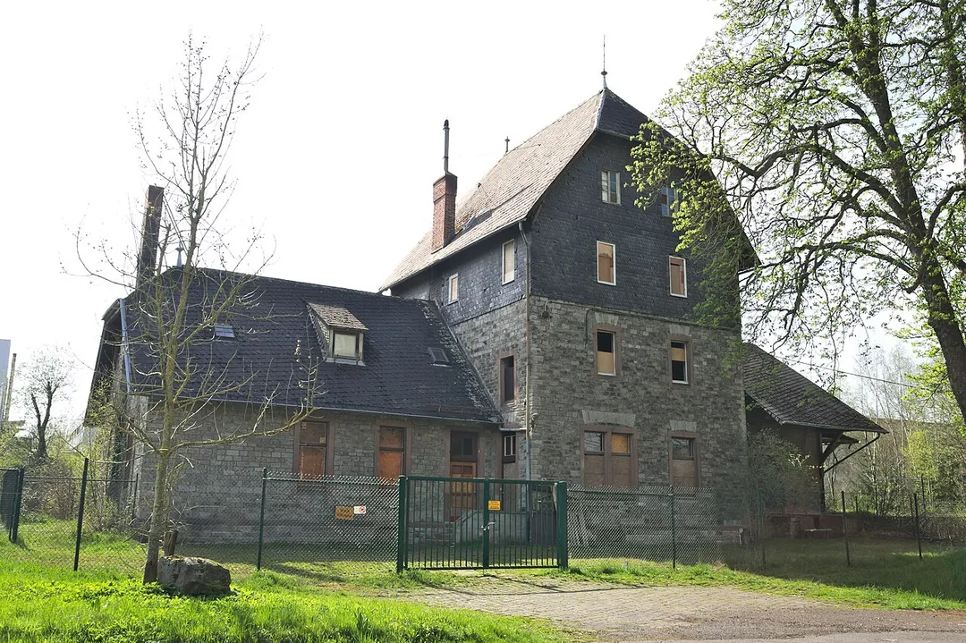 Cultural heritage monument; old train station in Dierdorf, Bahnhofstraße, Kreis Neuwied, Germany. Main building with three floors. Partly covered by slate, side buildings.