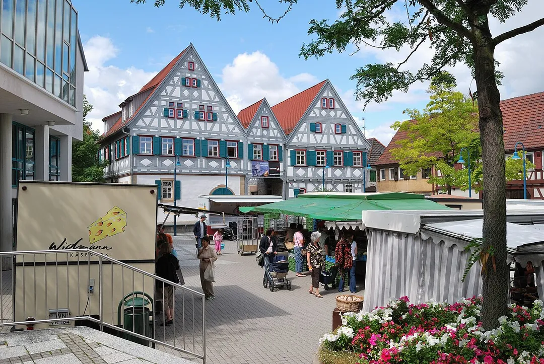 Weekly market in Ditzingen Am Laien, in Baden-Württemberg in Germany. In the background the Dreigiebelhaus (three-gables-house).