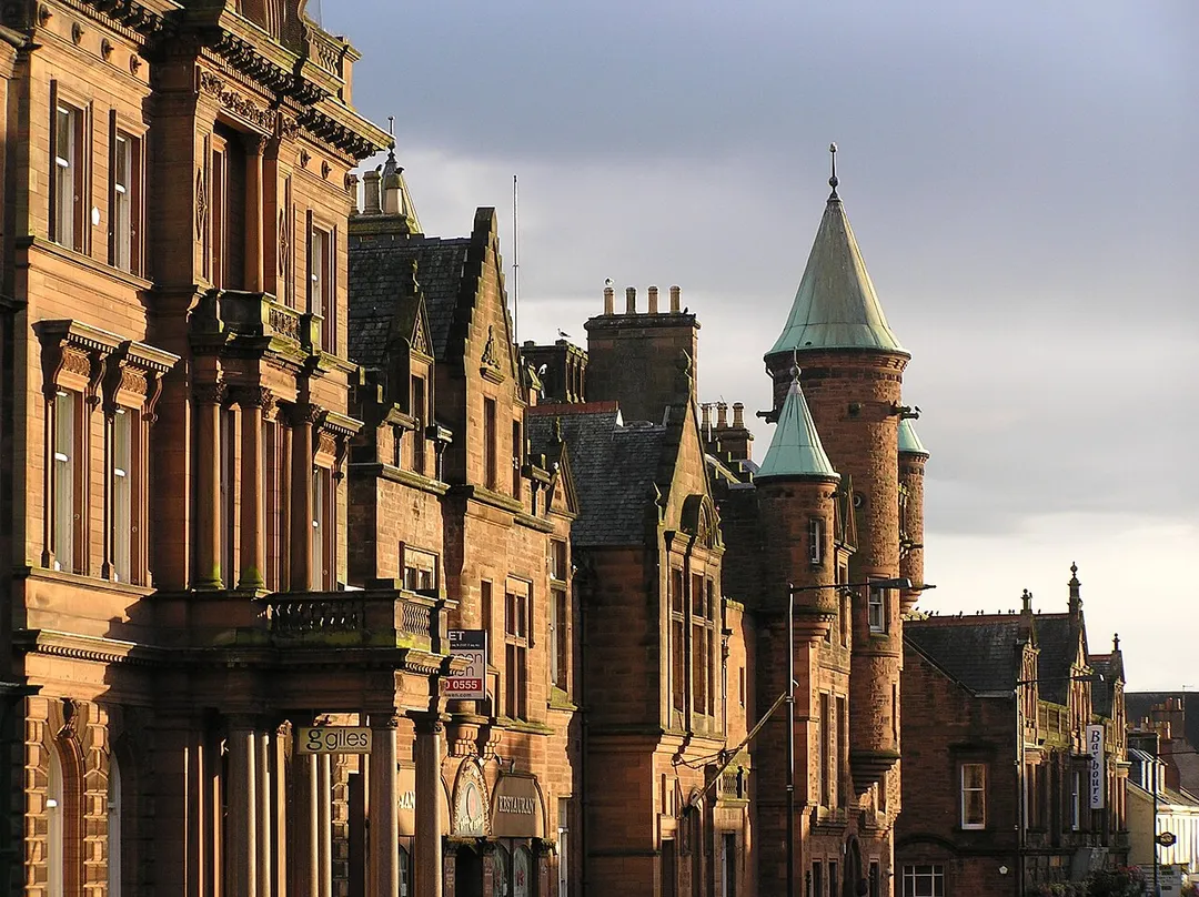 Red sandstone buildings, including the Sheriff Court, shops and offices, in Buccleuch Street, Dumfries, Scotland. Photographed early evening.