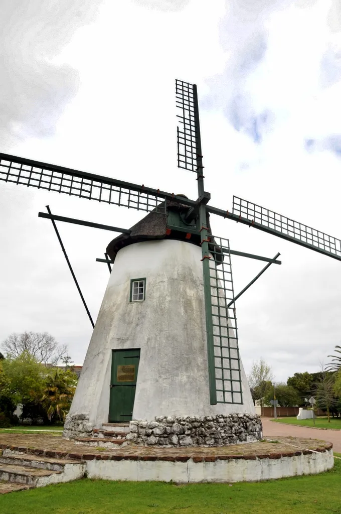 Front view of Onze Molen Mill, situated in Durbanville, Cape Town, on the corner of High and Onze Molen Streets. Onze Molen was built around 1801 and worked by wind through to the early 20th century. The sails, roof and machinery were removed at some time, and according to tradition the structure was used as a horse mill. In 1984 a restoration was undertaken by the Natal Building Society. The restoration included the reinstallation of machinery, but the mill is not operable. The mill is currently in a state of disrepair with a number of the supporting trusses visibly damaged and the thatch roof is visibly disintegrating.