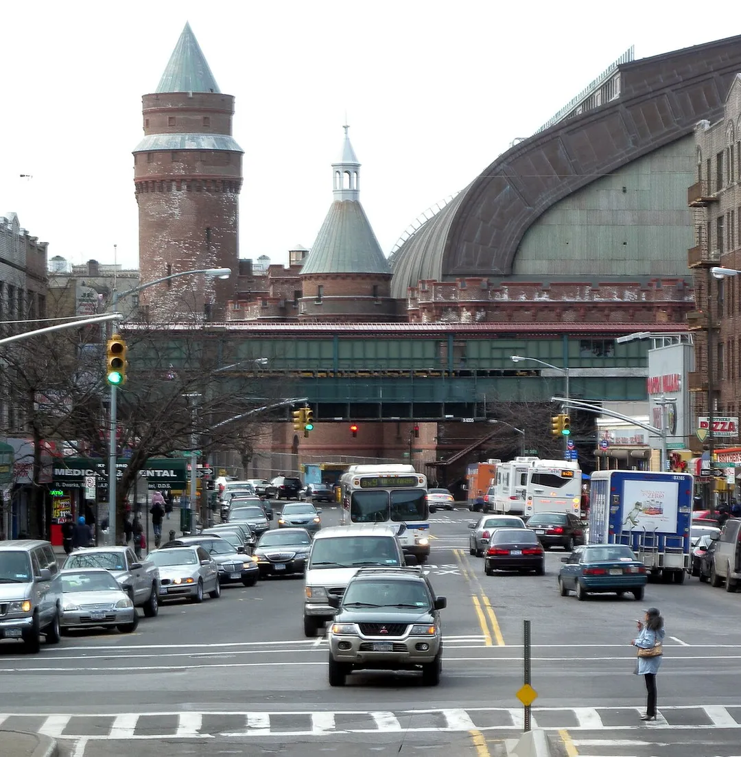 Looking northwest, full zoom, from Grand Concourse at en:Kingsbridge Road (IRT Jerome Avenue Line) with armory in background, on a cloudy afternoon.