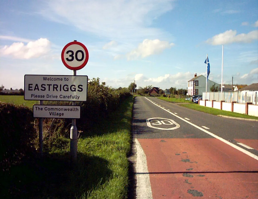 Approach to Eastriggs from the east showing the "Commonwealth Village" signpost.  Taken by me September 30th 2006.
