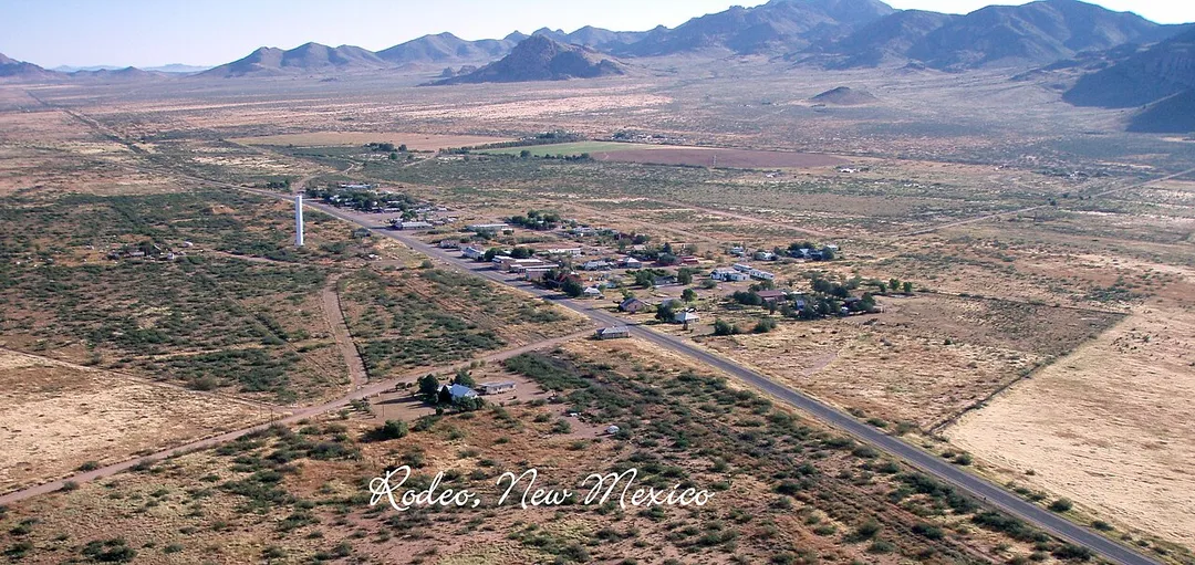 A low level aerial view of Rodeo, New Mexico from the southwest. The cropped mountain (flat top) is the highpoint of the en:Peloncillo Mountains (Hidalgo County), Gray Mountain, which is due east of Rodeo. (Clickable to High-Res; the straight-line road extension, north, is a gas pipeline, unimproved service road, through the mountains. A small escarpment due southeast is visible on right, and is on Atlas's, or topo maps.)