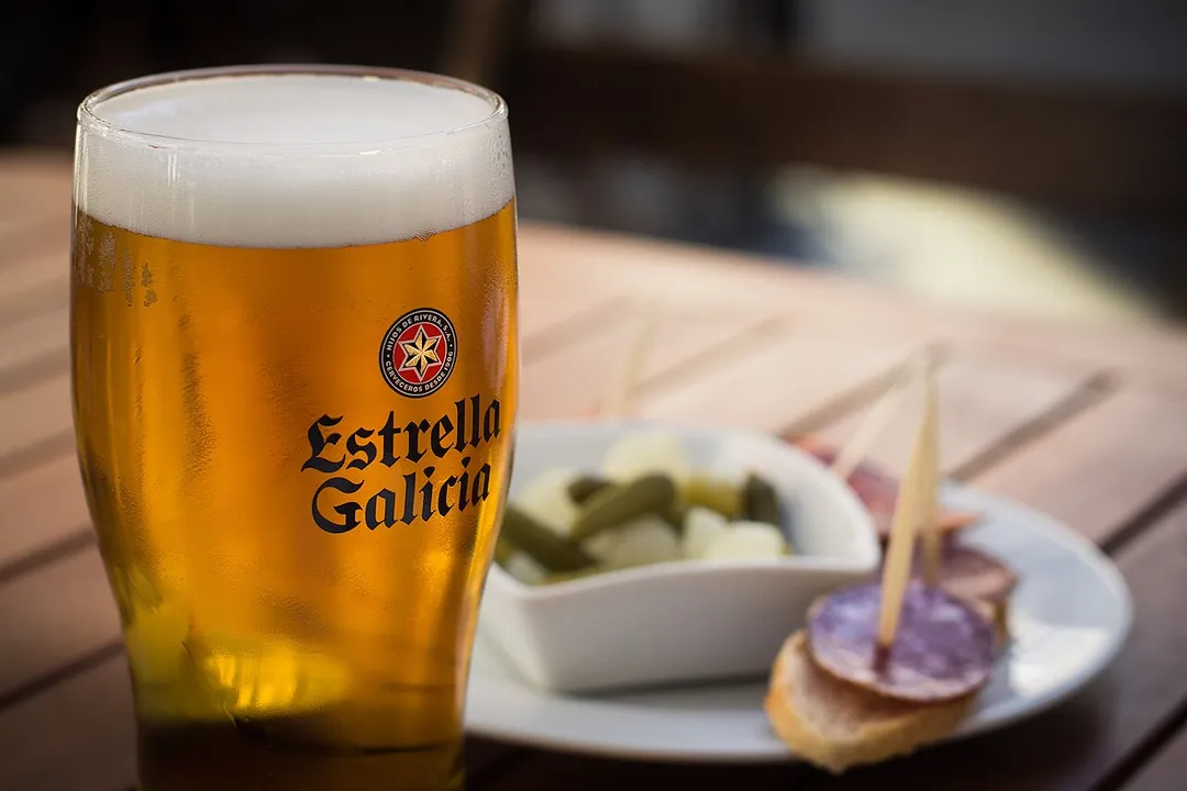 A large Estrella Galicia beer served alongside tapas in Santiago de Compostela