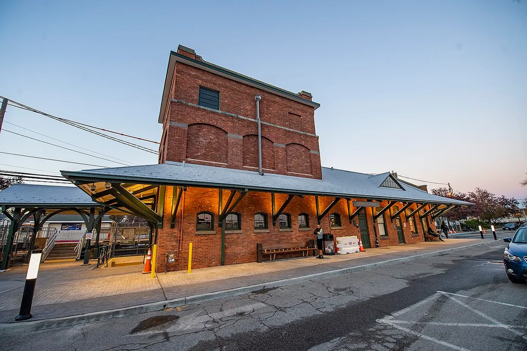 LIRR's Farmingdale Station, build in 1890 and listed on the National Register of Historic Places, was fully restored to its original historical brick architecture in 2018, capturing and preserving its history and character. In celebration of its rich history, historic photos were placed alongside a commemorative plaque in remembrance of its past.
Other station improvements include:
• Building upgrades: A new waiting room with terrazzo flooring, newly redone ADA accessible restrooms, tile and wood wall and ceiling finishes, windows, doors, electrical, plumbing and HVAC upgrades.
• Easier navigation: The pedestrian underpass rehabilitated, and new wayfinding signage installed along with, bike racks, benches, USB charging stations, technology counters, and LCD information displays to further enhance the customer experience.
• Safety and Efficiency: New CCTV cameras installed, platform repairs, and new LED platform lighting.
• Improved ADA accessibility: A new ramp was installed.
• Customer comfort: Free public Wi-Fi, digital information display totems, and new trash receptacles throughout the station.

Photo: MTA Capital Construction/Trent Reeves
