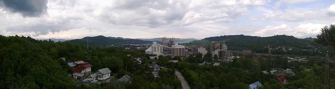 Imagine panoramică a Fabricii de Ciment văzută de pe vârful, numit La Stâlp, aflat în sudul Fieniului pe coama de deal numită Sfoara Scurtă al cărui capăt sfârşeşte în curba drumului judeţean, la capătul podului peste Ialomicioara.