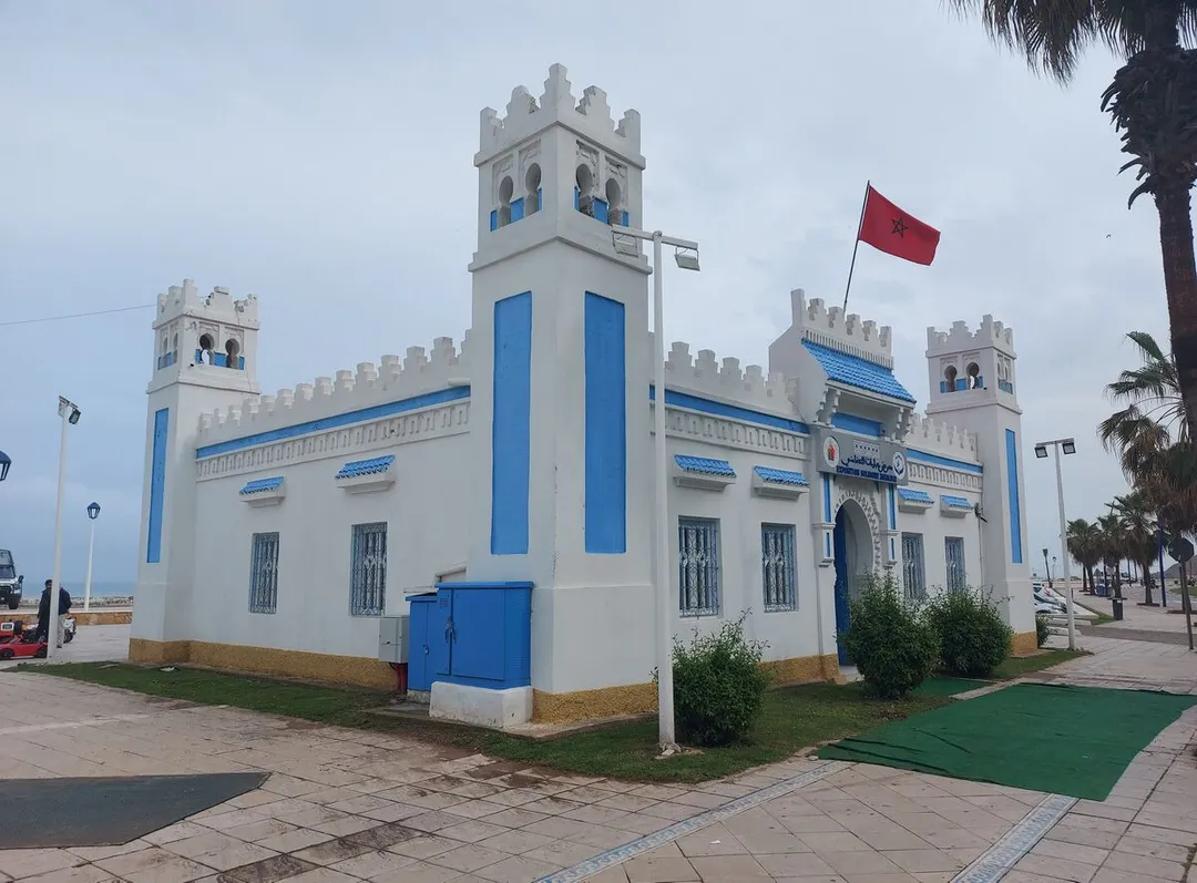 Cette image provient du Maroc dans le cadre du Wiki Challenge Ecole d'Afrique 2025 (https://fr.vikidia.org/wiki/Projet:WikiChallenge_%C3%89coles_d%27Afrique_2025/Maroc)
Il s'gait de la Vue extérieure de l’ancienne gare de Fnideq, aujourd’hui rénovée en centre solidaire Jabaliyat, arborant fièrement le drapeau marocain.
Cette image provient de : https://fr.vikidia.org/wiki/Gare_ferroviaire_de_Fnideq#/media/Fichier:Gare_ferroviaire_Fnideq.jpg dont l'auteur est Ibnbaja