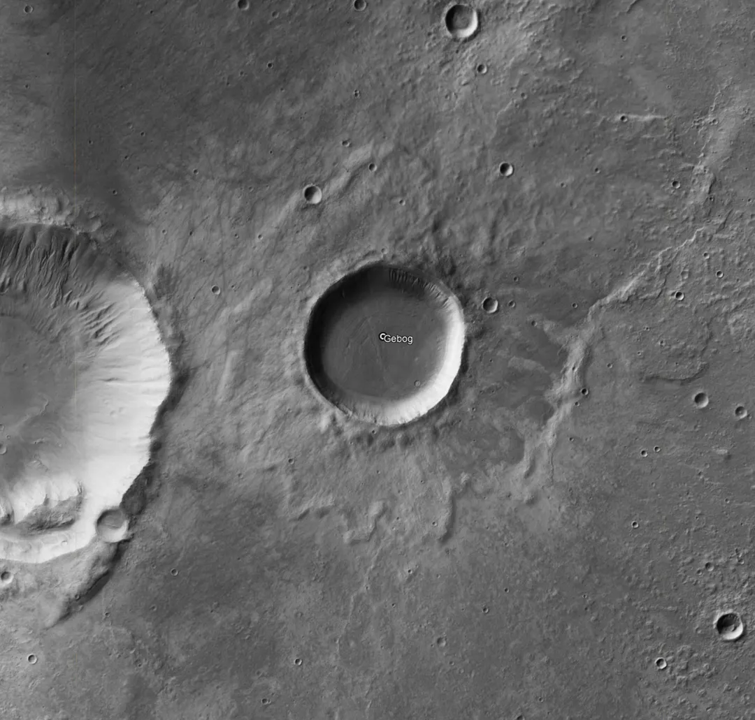 Grayscale Mosaic Image of the crater as it was taken by the HiRISE Context Camera (CTX) instrument aboard the Mars Reconnaissance Orbiter (MRO) during its many flybys of the planet Mars within its scheduled mission. The mosaic image was created using the many years of data collected from the Mars Reconnaissance Orbiter during its mission. It was then compiled and stitched together on April 5th, 2023, by Caltech at Murray Labs into a 5.7 terapixel global mosaic image of Mars. Obtain via screenshot from Google Earth Pro of the KML file from the website (https://murray-lab.caltech.edu/CTX/)