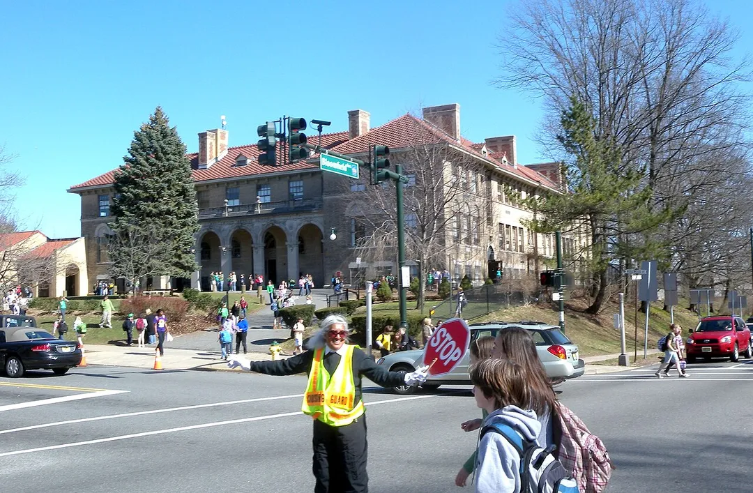 Looking east as crossing guard helps children cross Bloomfield Avenue on a sunny early afternoon.
