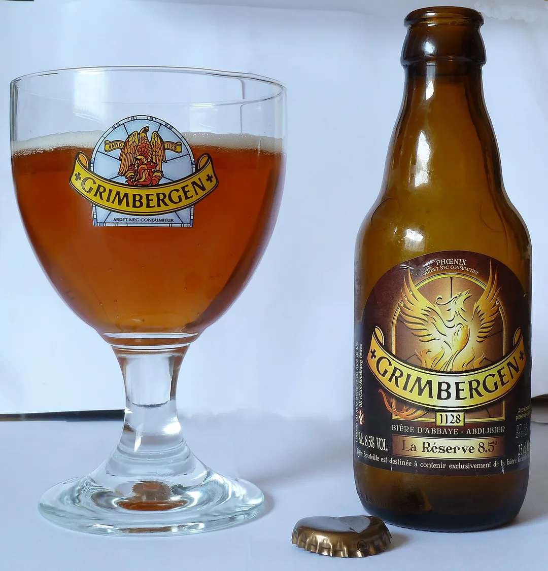 Eine Flasche Grimbergen La Réserve 8,5 mit Kelchglas.