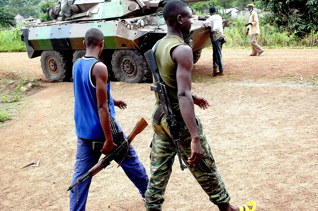 FAFN rebels are marching through an occupied village where a French armored car is standing making sure a strong relationship is kept between the French Foreign legion and the rebel troops.