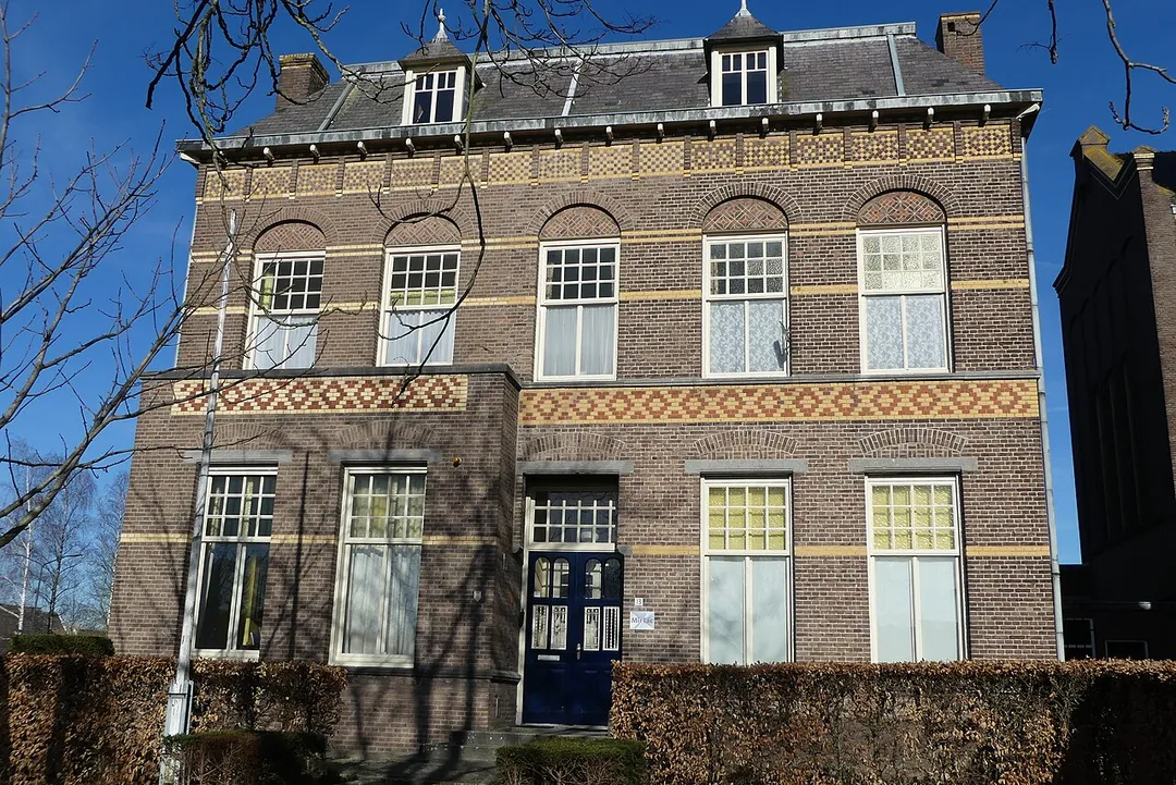 Zicht op een pand naast de Onze Lieve Vrouwe Onbevlekt Ontvangenkerk in een deel van de Kerkstraat in Hank