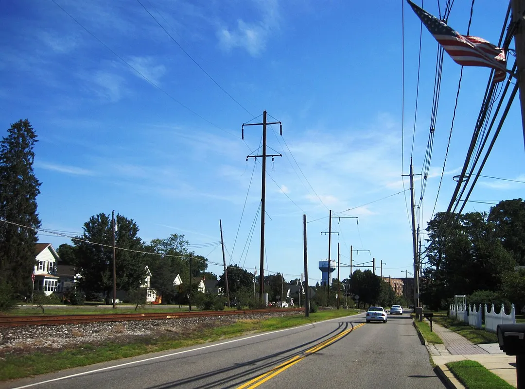 Photo of the center of Helmetta, New Jersey. Photo taken along northbound Main Street (County Route 615) approaching Willow Street. The Camden and Amboy Railroad, formerly electrified as a part of the PRR Jamesburg Branch, is on the left.